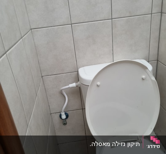 אסלה עם חיבורי מים בחדר אמבטיה